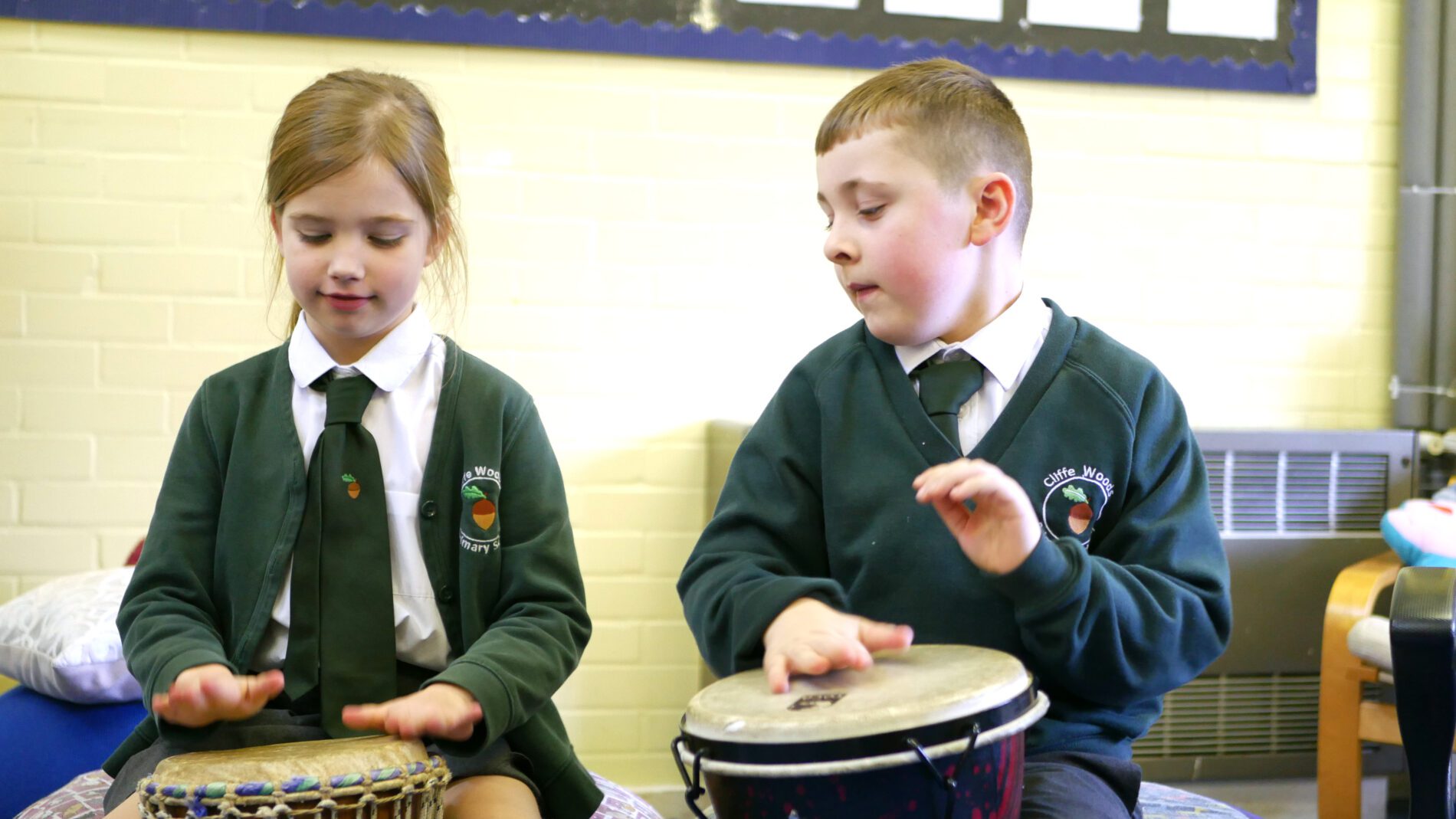 pupils learning to play african drums in music lessons at cliffe woods primary school