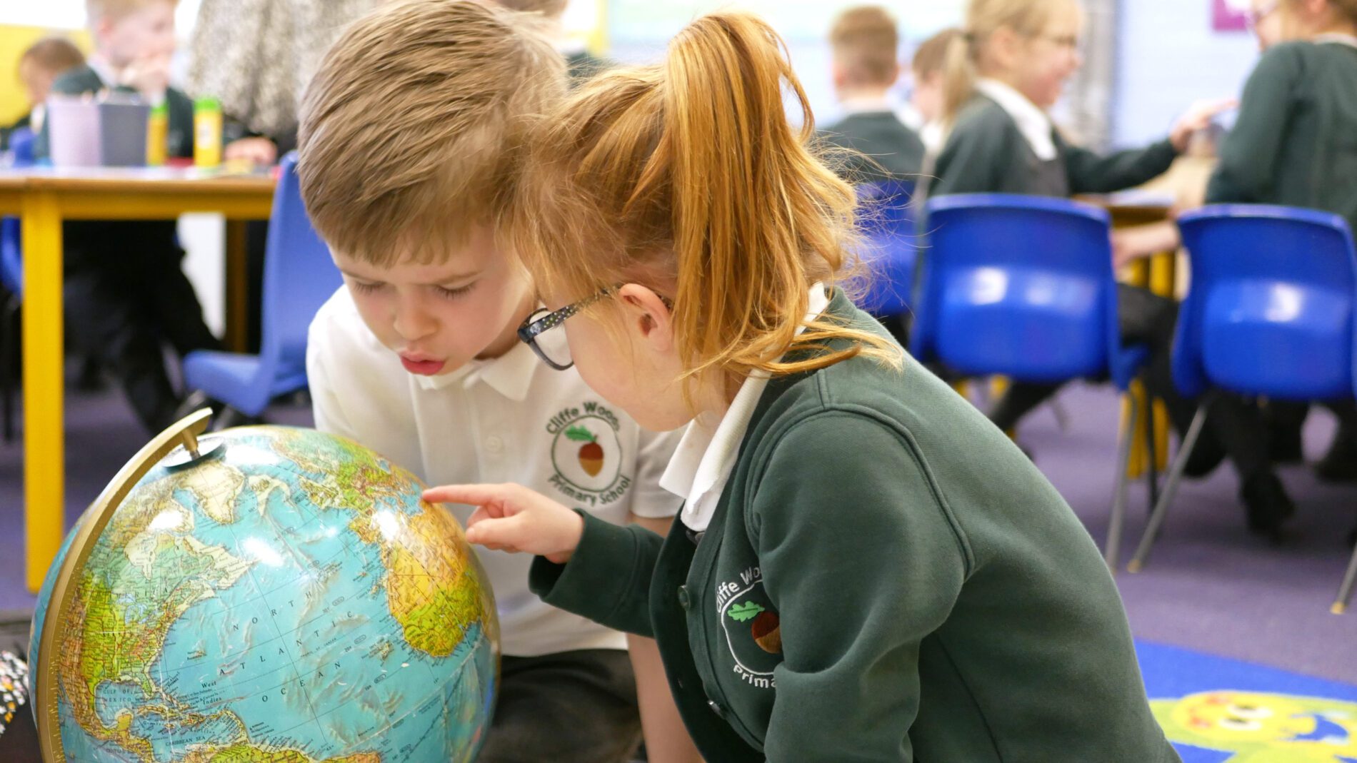 pupils looking at the globe in georgraphy at cliffe woods primary school