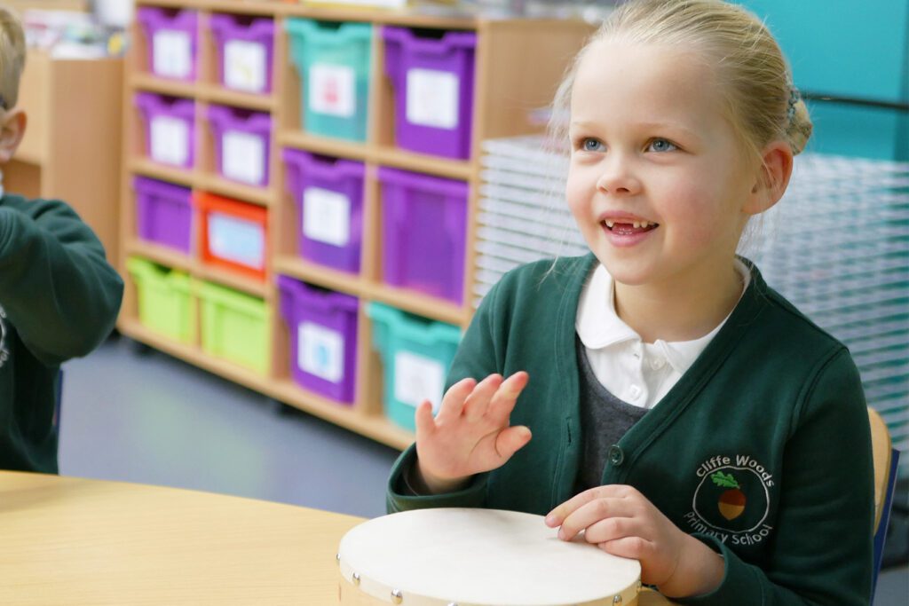 pupil learning to play the drum in music lesson at cliffe woods primary school