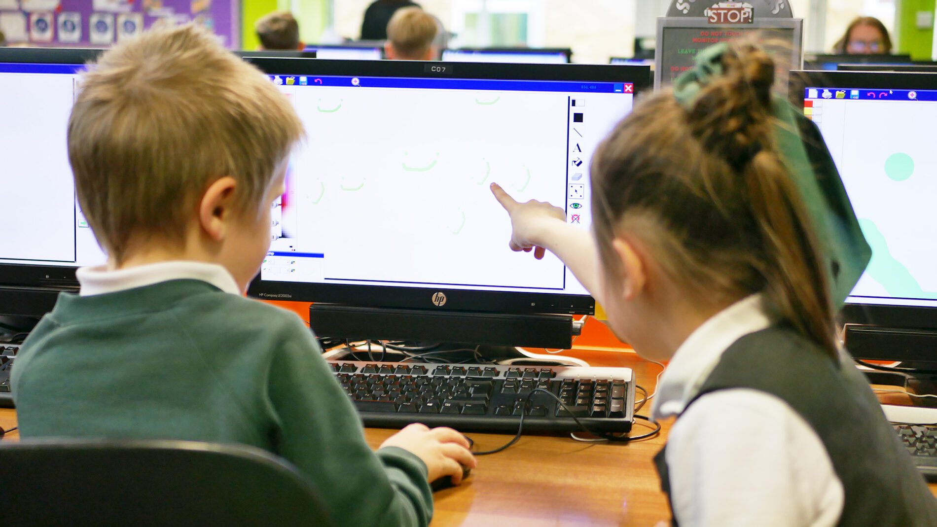 pupils pointing and working together in computing class at cliffe woods primary school